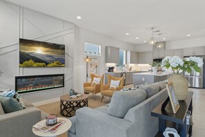 Stylish open-concept living space with a cozy fireplace, modern decor, and abundant natural light.