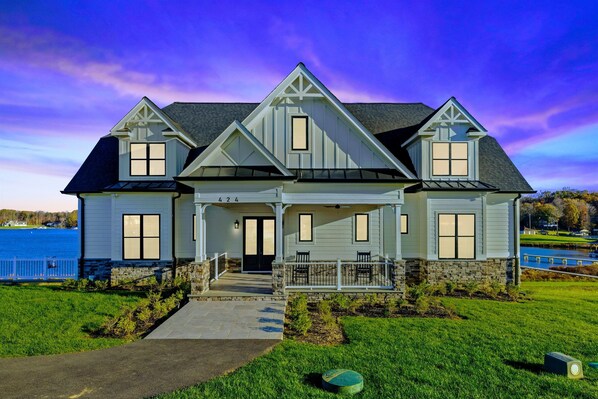 Stunning lakeside home with a modern farmhouse design, expansive front porch, and picturesque water views.