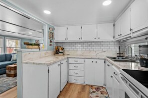 Whether you're whipping up a gourmet meal or just brewing your morning coffee, this sleek kitchen with white cabinets is where the magic happens!