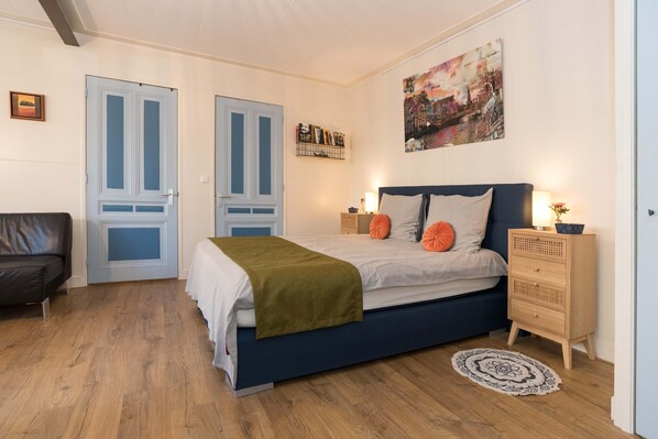 Spacious and bright apartment featuring a comfortable double bed and direct access to a private bathroom with modern amenities, perfect for a relaxing stay.

