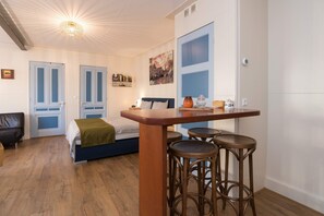 Bright and welcoming apartment with a cozy seating area, TV, and fully equipped kitchen — perfect for relaxing after a day of exploring Alkmaar.