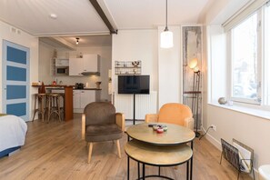 Bright and welcoming apartment with a cozy seating area, TV, and fully equipped kitchen — perfect for relaxing after a day of exploring Alkmaar.