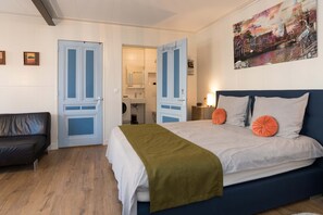 Spacious and bright apartment featuring a comfortable double bed and direct access to a private bathroom with modern amenities, perfect for a relaxing stay.

