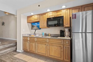 This stocked kitchen has all the amenities to make your stay feel like home.  40" Smart TV, Full-sized Refrigerator, Microwave, Sink, Countertop Burners, Drip and K-Cup Coffee Makers, Dinnerware, Silverware, Utensils, and Cookware.  Enjoy your stay!