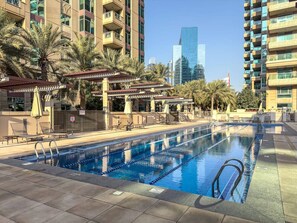 Pool Oasis: Dive into relaxation at the sparkling pool surrounded by lush palms and city views!