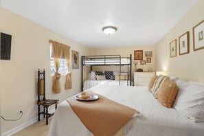 Bedroom 1- king bed, bunk bed, wall mounted TV, work space, dresser, lighting