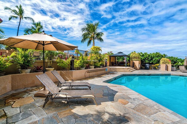 Relaxing poolside with lounge chairs and lush tropical landscaping.