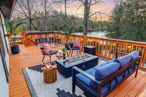 Unwind on the spacious upper deck with a firepit and lakefront scenery.
