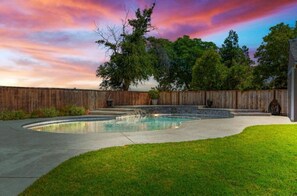 Unwind in the tranquility of this spacious backyard, featuring a private pool and stunning sunset skies. Ideal for group gatherings and family retreats in Oakdale.