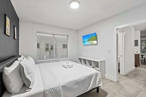 Relax in this modern bedroom with a comfy bed and a serene atmosphere, perfect for unwinding after a day of exploring.