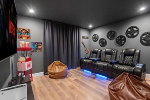The home theater’s reclining seats, movie-themed decor, and comfy bean bags turn film nights into an immersive, cinematic experience.