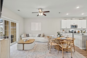 The living room has an open design that flows into the dining room and kitchen