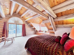 King Ensuite Bedroom with pine vaulted ceilings with a private balcony and mountain views