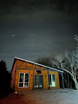 Modern cabin with black bear and lots of exterior lighting to welcome you.