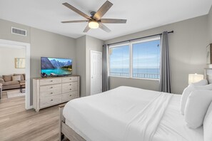 Master bedroom with a comfortable king-size bed, flat-screen TV, and stunning ocean views.