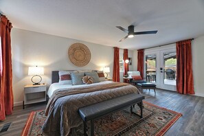 Spacious and inviting master bedroom with warm accents, a private patio entrance, and a comfortable lounge area to unwind