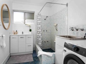 Indulge in relaxation with this well-appointed bathroom, featuring a bathtub, a separate shower, and a modern vanity with ample counter space.