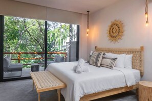 Modern and minimalist room with a comfortable king-size bed. It has a private balcony and armchairs for relaxation. Spectacular exterior view.