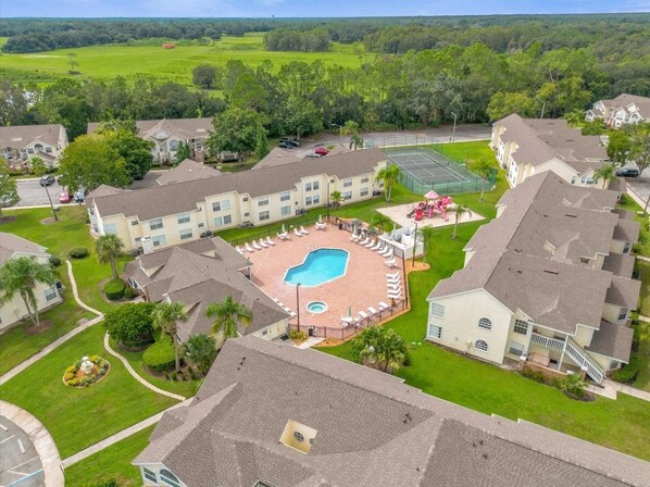 Drone pic with pool, hot tub, playground, and tennis court visible.