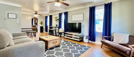 Living area provides an over sized comfy couch along with a love seat, smart tv