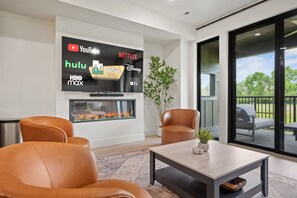 Experience the cozy living room, outfitted with plush seating, a fireplace, an expansive smart TV, and patio doors that frame the breathtaking mountain vistas.