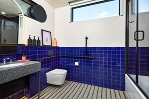 A bright and spacious bathroom with bold tilework, a sleek vanity, and a walk-in shower, creating a refreshing and stylish retreat.