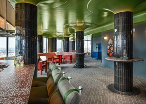A stylish and vibrant space with bold decor and modern seating, offering the perfect setting for socializing and unwinding above the city.
