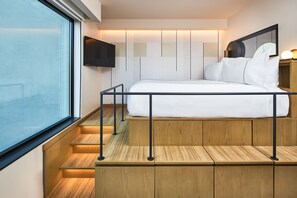 A lofted bed setup with built-in storage, maximizing space while maintaining a cozy and elevated feel.