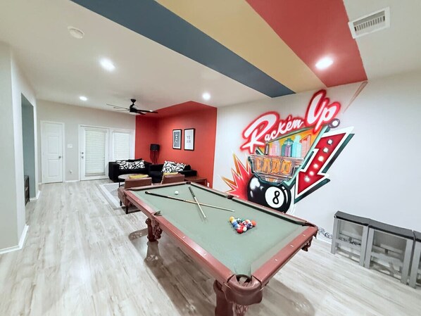 Bring the fun to your stay with this vibrant game room featuring a pool table, bold decor, and a custom 'Rack'em Up' mural. Perfect for friendly competitions and making memories while relaxing in Houston’s EaDo neighborhood!