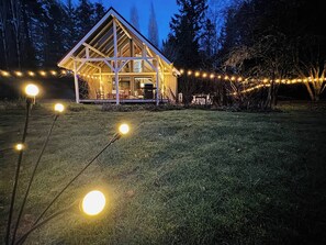 The house at dusk with solar and LED string lighting creates a charming and beautiful atmosphere on the spacious property
