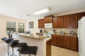 The breakfast bar serves as a functional and inviting centerpiece of the kitchen, offering a space for casual meals, snacks.
