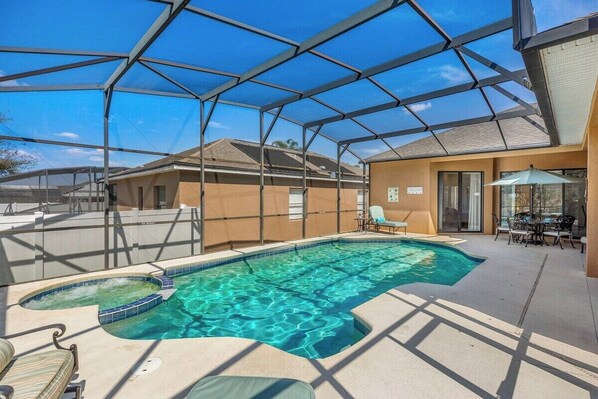 Spacious pool with spa and outdoor dining area