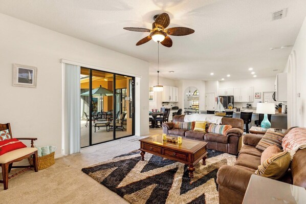 Comfortable family room, open to the kitchen, doors to pool area