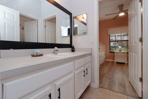 The attached en-suite bath provides added privacy and convenience, with modern fixtures, a spacious shower, and soft, fluffy towels.