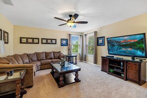 At the heart of the room, a large flat-screen TV serves as the focal point, offering an immersive viewing experience.