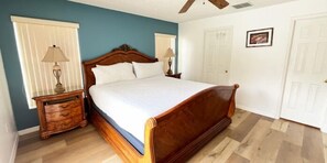 King-size bed, ceiling fan, pool access door, located at the back right of the home with en-suite bathroom.