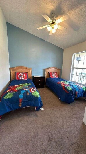 A twin bedroom with two beds, inspired by Captain Marvel, offers a fun and dynamic space for fans of the superhero, blending excitement and comfort.