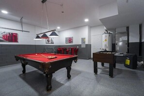 An exciting game room with a pool table and foosball combines elements of fun, competition to unwind