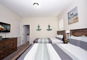 Ground floor bedroom with two full-size beds, flatscreen TV, slide closet w/ en-suite bathroom.