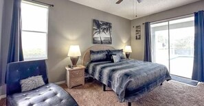 Relax in this serene master bedroom with plush bedding and direct access to the private screened-in pool. Located near Disney in sunny Orlando, it's your peaceful retreat after theme park fun.