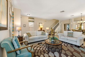 Picture a cozy sitting room designed for relaxation and comfort. The room features plush, inviting couches arranged to create a welcoming atmosphere.
