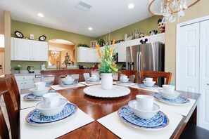 Gather around the large dining table that seats the whole group in comfort. The setting is ideal for family meals, celebrations, or casual breakfasts before hitting the parks.