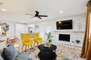 With cheerful pops of yellow and thoughtful curated décor, this open-concept living room makes chatting and catching up with your companions a breeze!