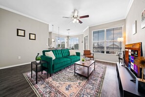 Bright and airy living room with plush seating, a large TV, and tasteful decor, creating the perfect space for relaxation and entertainment.