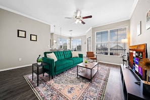 Bright and airy living room with plush seating, a large TV, and tasteful decor, creating the perfect space for relaxation and entertainment.