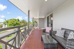 Start your day with coffee or unwind in the evening on the spacious balcony, complete with comfy seating and serene leafy views.