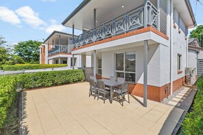 Step into your private outdoor sanctuary, where a lush green garden and a six-seater dining set invite you to enjoy alfresco meals under the open blue skies.