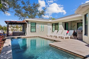 A stunning private pool area. Featuring a sparkling pool, comfortable sun loungers, and lush tropical landscaping, this outdoor oasis is a feast for the senses.