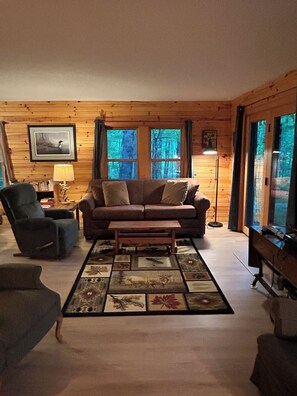 East side of the living room. Queen sofa bed. Laminate/rug.