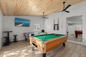 A bright, open game room filled with natural light, creating a fun and lively space for entertainment and relaxation!